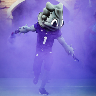 SuperFrog running on to the field at Amon G. Carter Stadium.