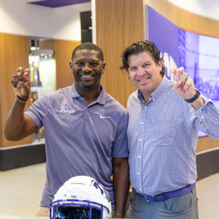 LaDainian Tomlinson and Chancellor Daniel Pullin give the Go Frogs hand sign.