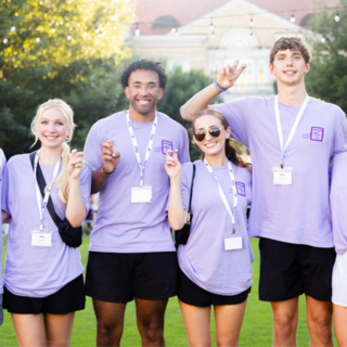 Four students showing the frog hand sign