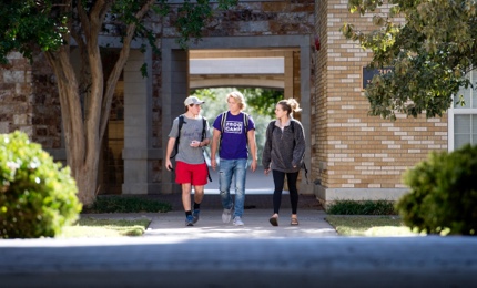 Three students walking on campus Three students walking on campus