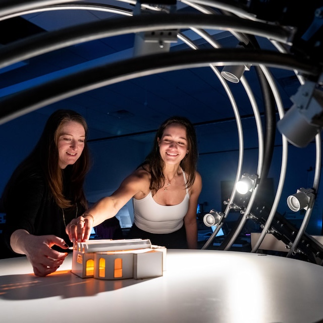 Professor and student lighting a small scale architectural model