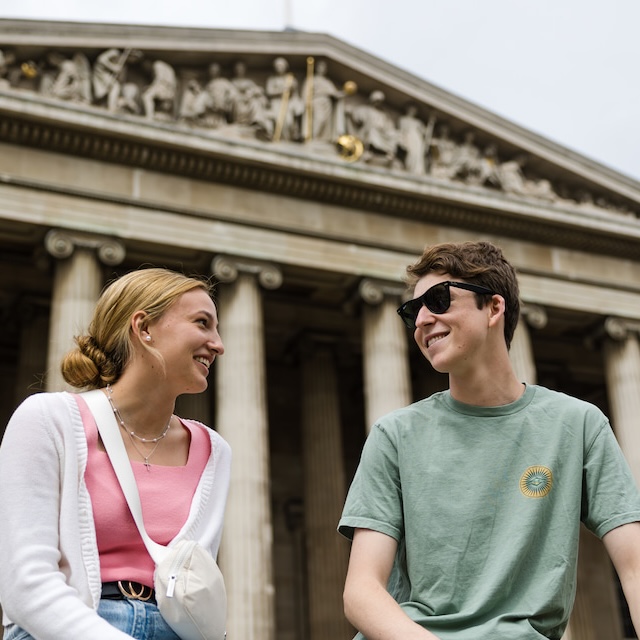 A female and male student sitting in front of the British Museum