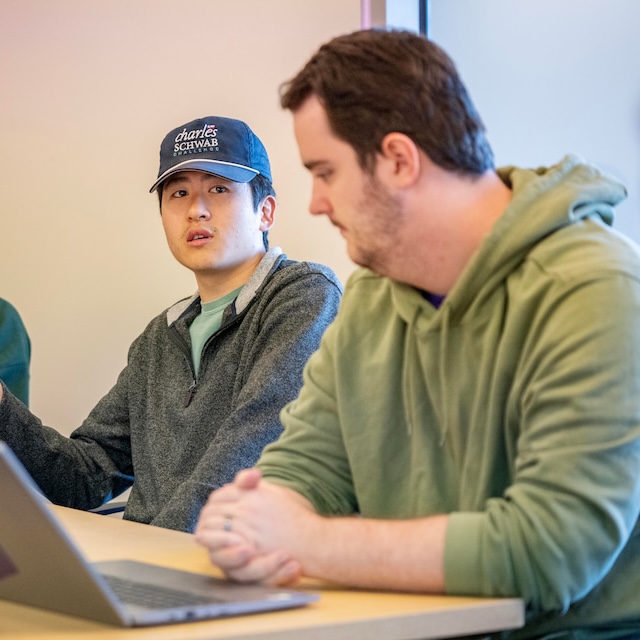 Student in class speaks as other students listen on