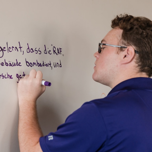 Students writes in German on dry-erase board