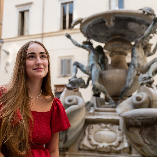 Student sits in front of Italian fountain