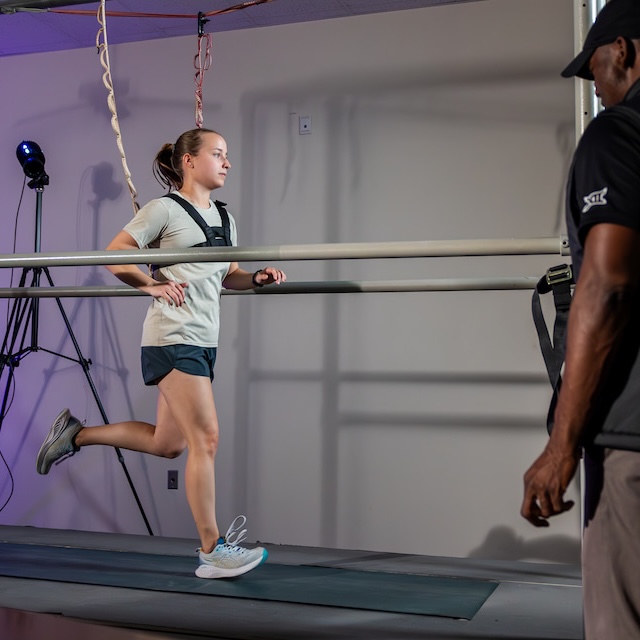 Person observes runner on treadmill