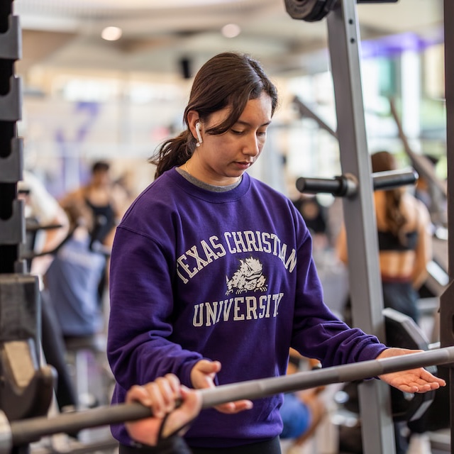 A person spots a weightlifter