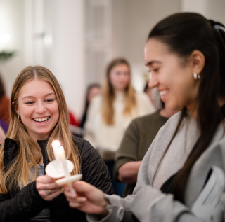 Two students light candles during TCU's annual candlelight service. Two students light candles during TCU's annual candlelight service.