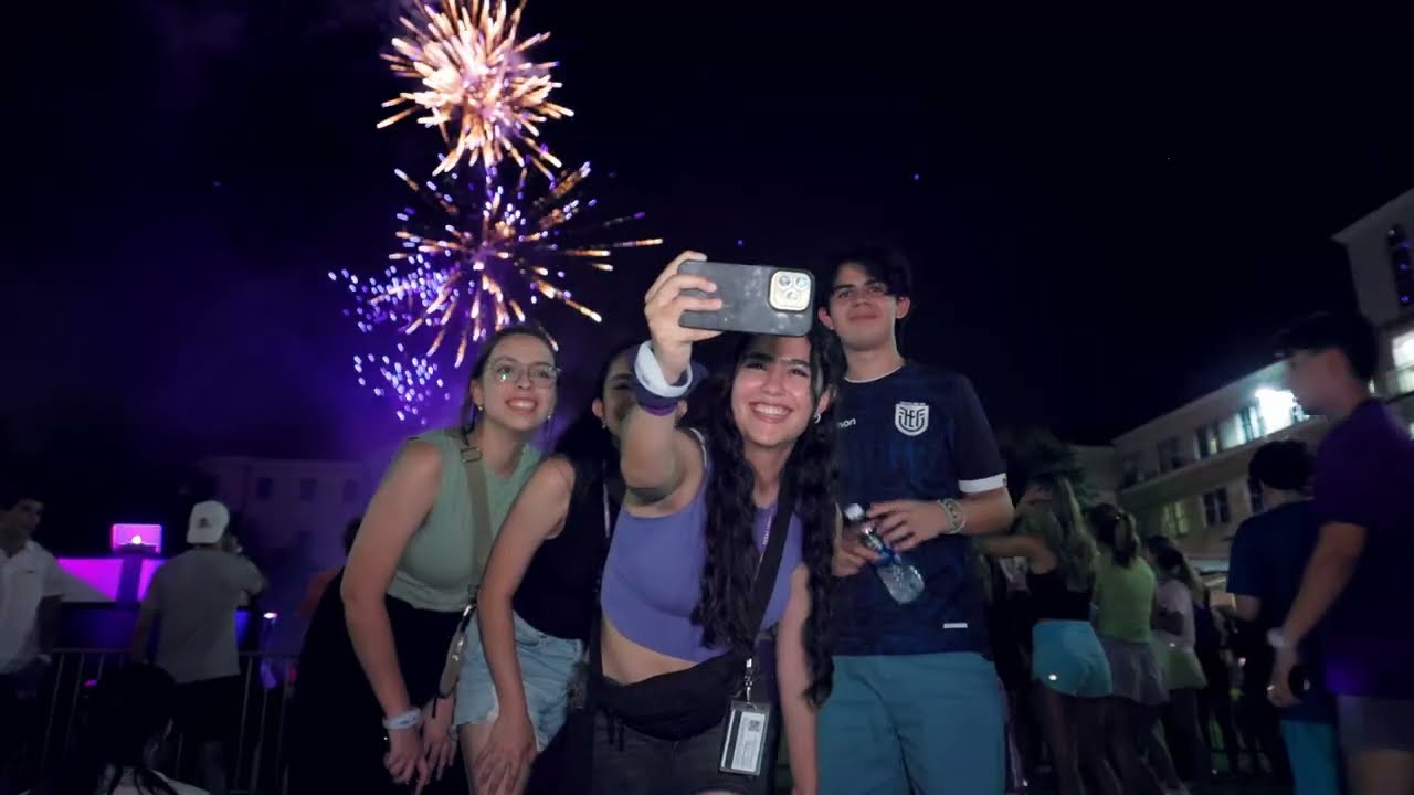 Four TCU students taking a selfie with fireworks in the background